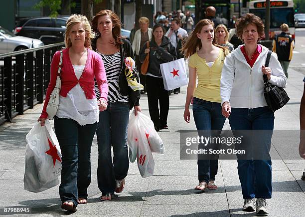 Shoppers carry their purchases along the Michigan Avenue shopping district May 26, 2009 in Chicago, Illinois. The Conference Board said Tuesday that...