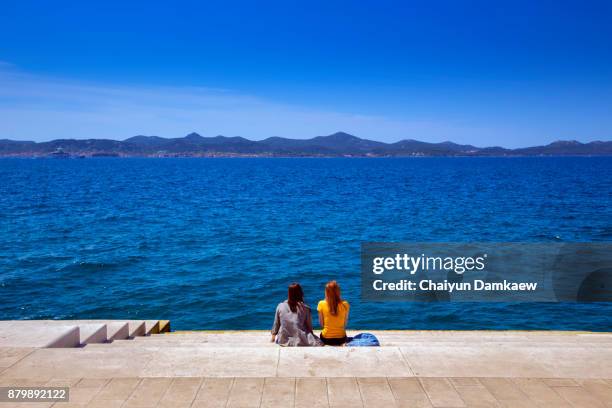 two cute girls friend relax on the beach. happy island lifestyle. - kroatien zadar stock pictures, royalty-free photos & images