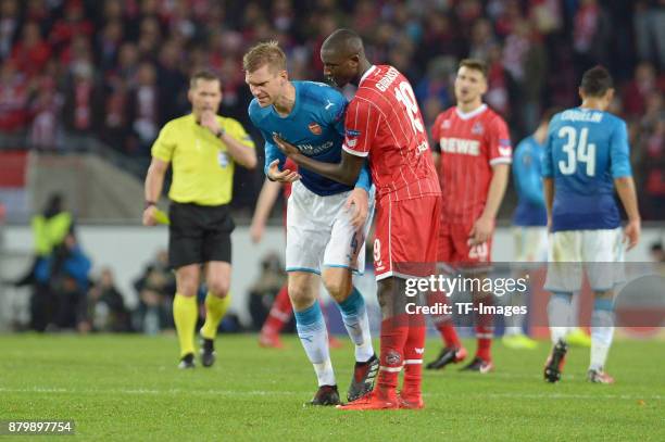 Sehrou Guirassy of Cologne helps Per Mertesacker of Arsenal during the UEFA Europa League Group H soccer match between 1.FC Cologne and Arsenal FC at...