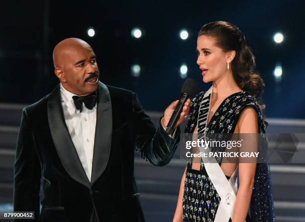 Host Steve Harvey speaks to Miss Thailand 2017 Maria Poonlertlarp during the 2017 Miss Universe Pageant on November 26, 2017 in Las Vegas, Nevada...