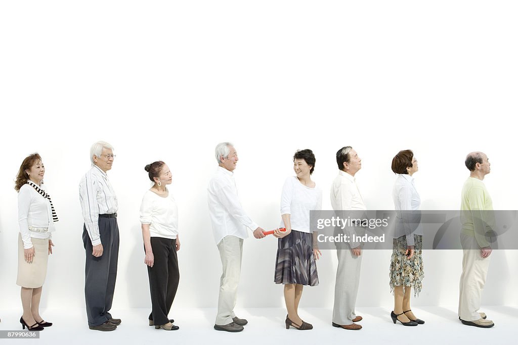 Man passing baton to woman in a row