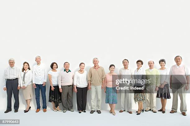 mature and senior adults smiling side by side - gente en fila fotografías e imágenes de stock