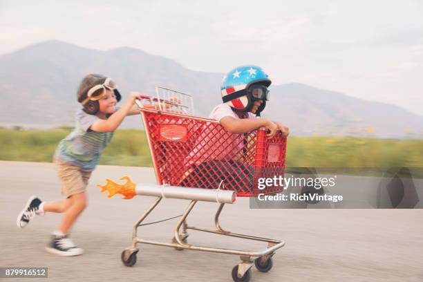 young boy shopping cart racing team - offbeat imagens e fotografias de stock