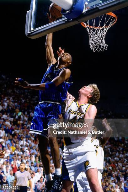 Anfernee Hardaway of the Orlando Magic shoots a layup against Rick Smits of the Indiana Pacers in Game Four of the Eastern Conference Finals as part...