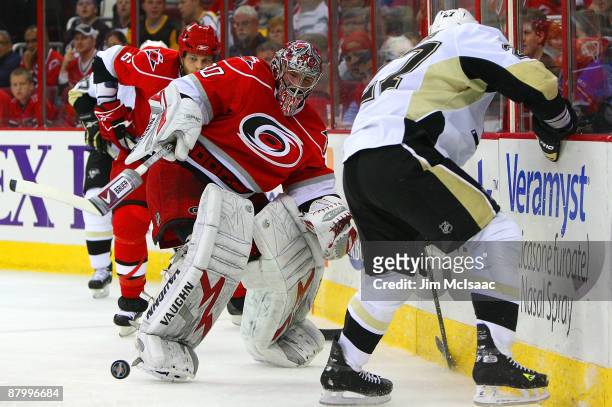 Goaltender Cam Ward of the Carolina Hurricanes clears the puck against Craig Adams of the Pittsburgh Penguins during Game Four of the Eastern...