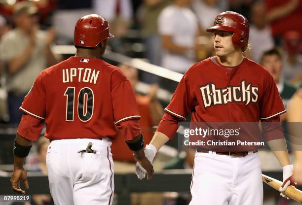 Mark Reynolds of the Arizona Diamondbacks congratulates teammate Justin Upton after he scored a sixth inning run against the San Diego Padres during...