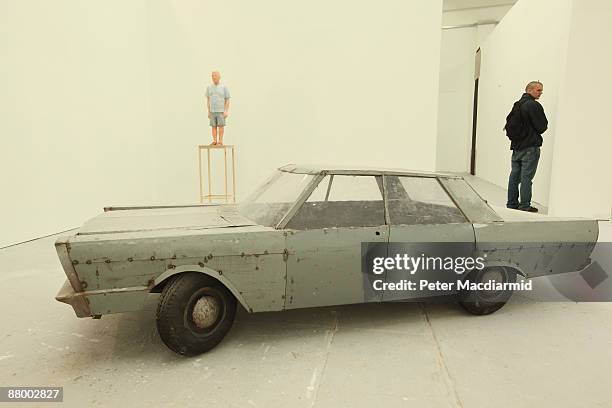 Sculpture of a car by Rob Eagle entitled 'Ford ' is exhibited in front of another sculpture entitled 'Dad In Sandals' at the Royal College of Art...