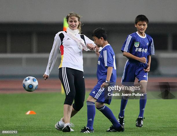 Fencing olympic champion Britta Heidemann practices with members of a chinese "U12 team" after the Germany training session at the Shanghai Stadium...