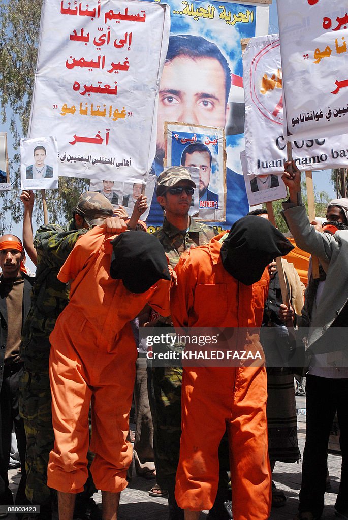 Yemenis dressed in orange jumpsuits and
