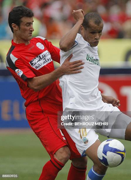 Brazilian Rivaldo of Uzbek champions Bunyodkor is stopped by Iran's Piroozi player Nabiollah Bagheriha during their AFC Champions League round 16...