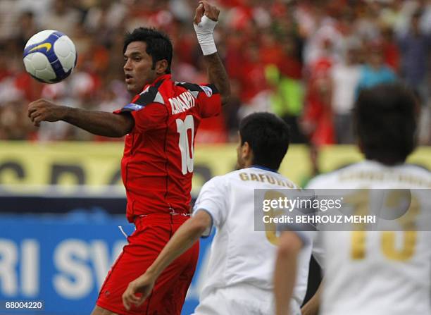 Iran's Piroozi player Alireza Nikbakht Vahedi competes with Uzbek champions Bunyodkor footballers Anvar Gafurov and Alexander khvostunov during their...