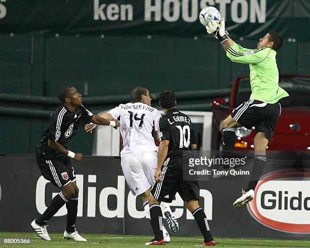 Rodney Wallace and Christian Gomez of D.C. United watch Nick Rimando of Real Salt Lake grab the ball in the air during an MLS match at RFK Stadium on...