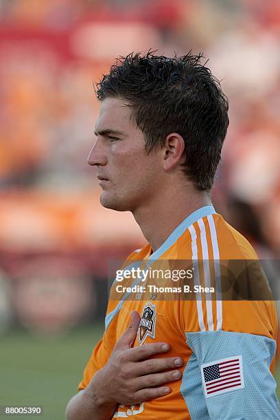 Bobby Boswell of the Houston Dynamo stands for the national anthem before the Dynamo played against the San Jose Earthquakes heads the ball at...