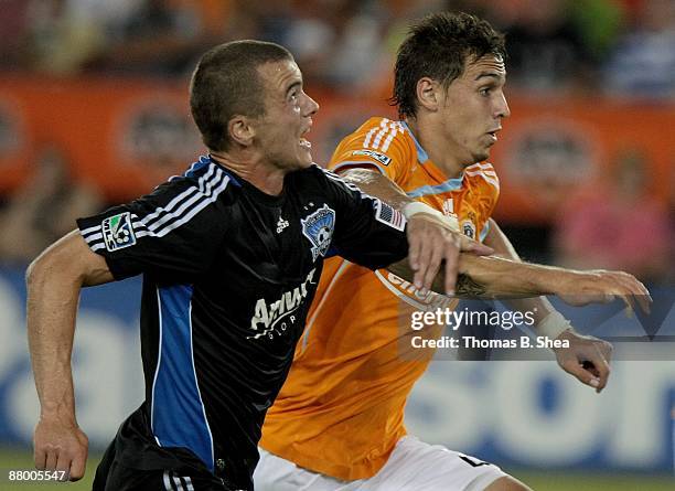 Geoff Cameron of the Houston Dynamo holds off Eric Denton of the San Jose Earthquakes at Robertson Stadium on May 23, 2009 in Houston, Texas.