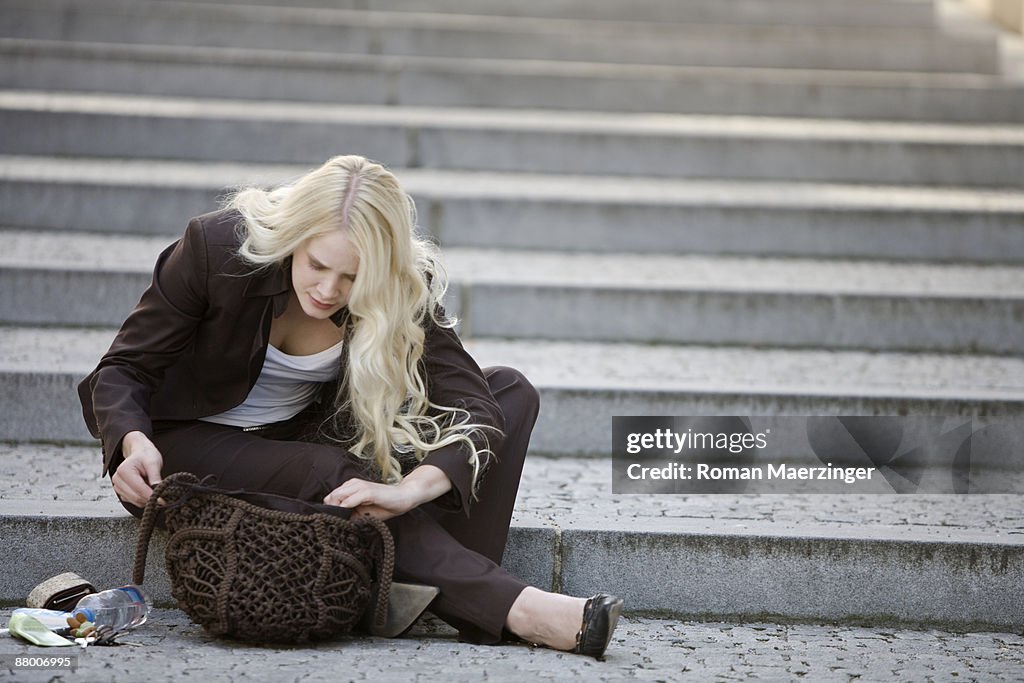 Young woman seeking for something in handbag