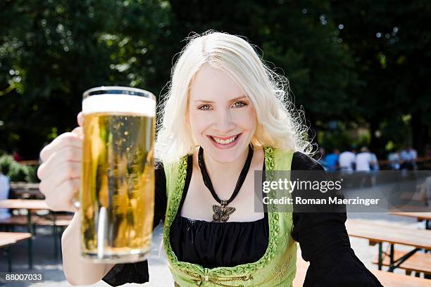 germany, bavaria, munich, english garden, young woman holding beer stein, smiling, portrait - ölsejdel bildbanksfoton och bilder