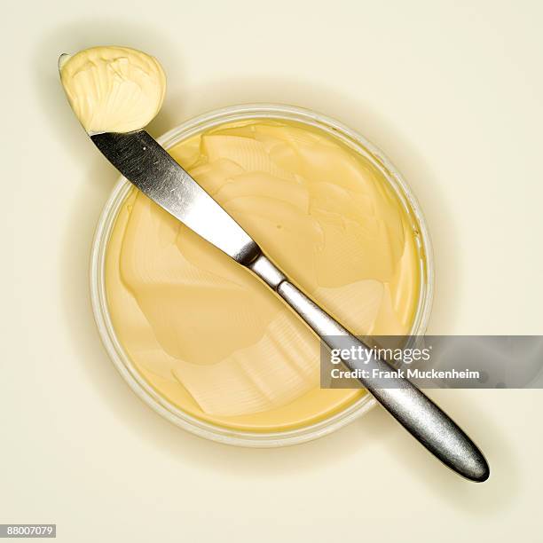 margarine curl lying on back of a knife, elevated view - butter curl stock-fotos und bilder