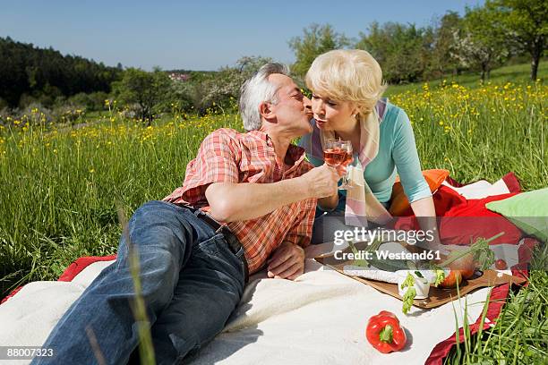 germany, baden württemberg, tübingen, senior couple having picnic, senior man kissing senior woman - tübingen stock pictures, royalty-free photos & images