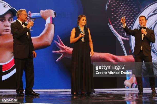 John Newcombe medallist Ashleigh Barty is toasted on the podium with John Newcombe and host Rove McManus at the 2017 Newcombe Medal at Crown...
