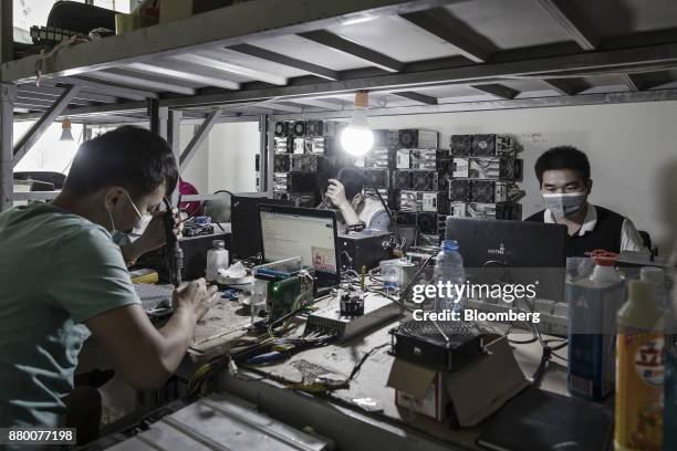 Technicians make repairs to bitcoin mining machines at a mining facility operated by Bitmain Technologies Ltd. In Ordos, Inner Mongolia, China, on...