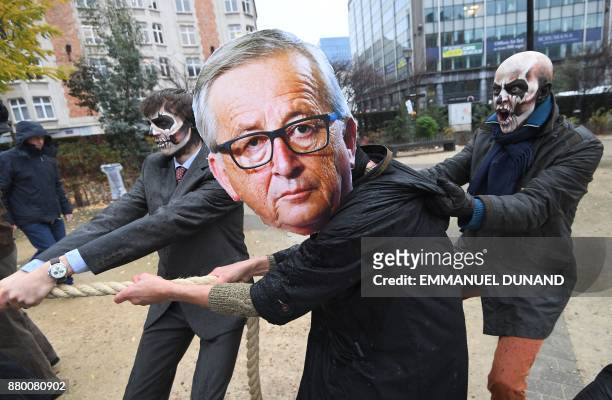 Activists acting as European Commission President Jean-Claude Juncker and Monsanto-characters with their faces painted with a skull enact a...