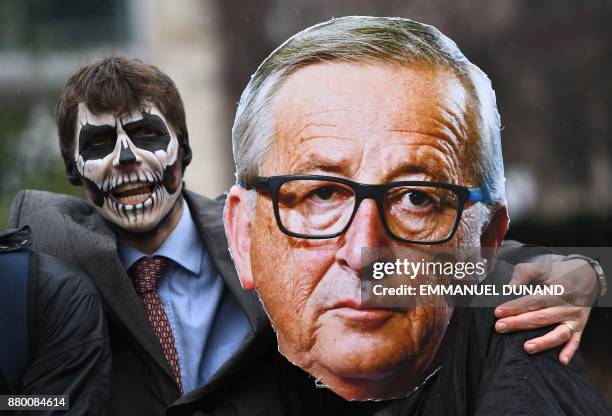 Activists acting as European Commission President Jean-Claude Juncker and a Monsanto-character with his face painted with a skull enact a tug-of-war...