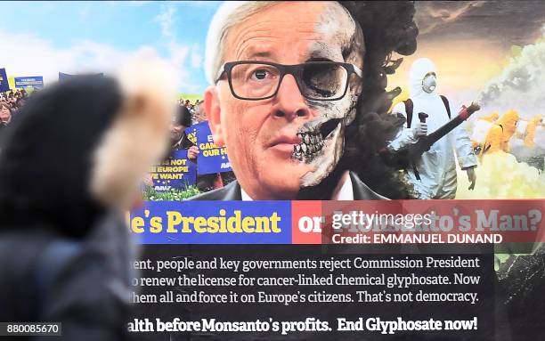 Pedestrian looks at a truck displaying a billboard featuring European Commission President Jean-Claude Juncker during an action calling for the EU...