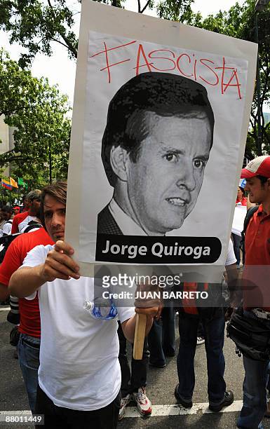 Supporter of Venezuelan President Hugo Chavez holds a sign with an image of Bolivian former president Jorge Quiroga reading "Fascist" during a...