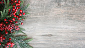 Holiday Evergreen Branches and Berries Over Wood