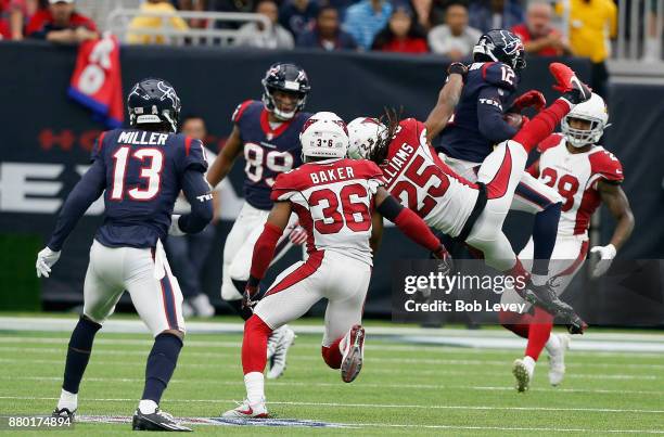 Bruce Ellington of the Houston Texans makes a catch as Tramon Williams of the Arizona Cardinals makes the tackle at NRG Stadium on November 19, 2017...