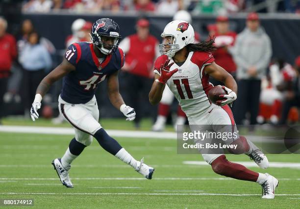 Larry Fitzgerald of the Arizona Cardinals runs with the ball as Zach Cunningham of the Houston Texans pursues at NRG Stadium on November 19, 2017 in...