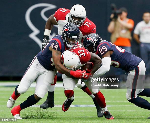 Kerwynn Williams of the Arizona Cardinals is tackled by Jelani Jenkins of the Houston Texans and Andre Hal at NRG Stadium on November 19, 2017 in...