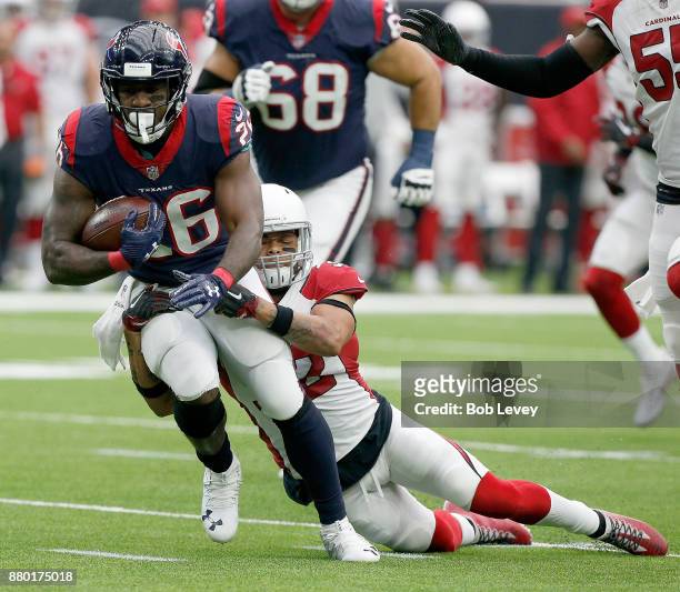 Lamar Miller of the Houston Texans attempts to break the tackle attempt of Tyrann Mathieu of the Arizona Cardinals at NRG Stadium on November 19,...