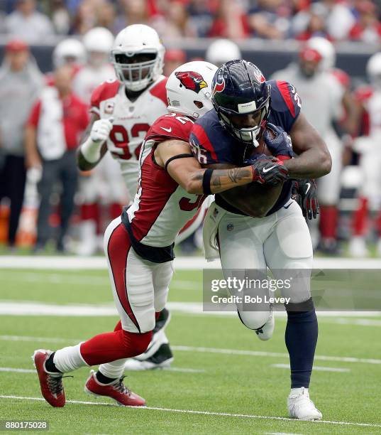 Lamar Miller of the Houston Texans is wrapped up by Tyrann Mathieu of the Arizona Cardinals at NRG Stadium on November 19, 2017 in Houston, Texas.