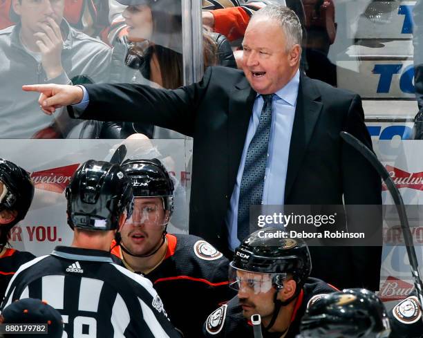 Head coach Randy Carlyle of the Anaheim Ducks talks with linesman Steve Barton during the second period of the game against the Vegas Golden Knights...