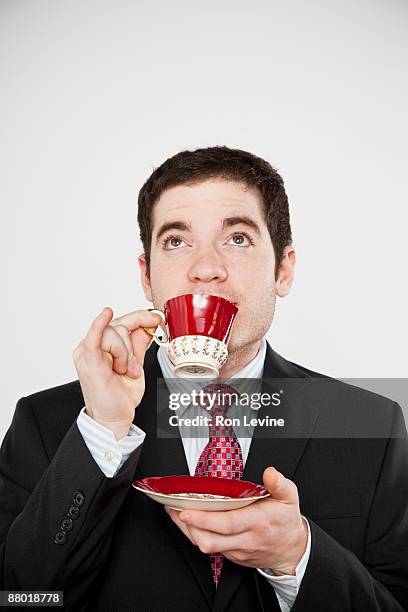 young man in suit sipping tea - pires imagens e fotografias de stock