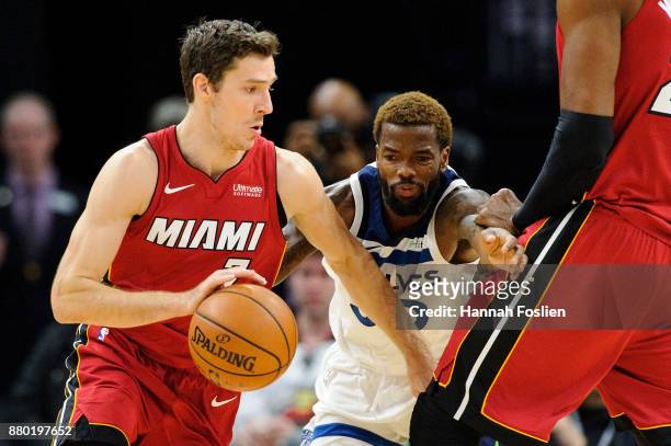 Hassan Whiteside of the Miami Heat sets a pick for Aaron Brooks of the Minnesota Timberwolves as teammate Goran Dragic drives to the basket during...