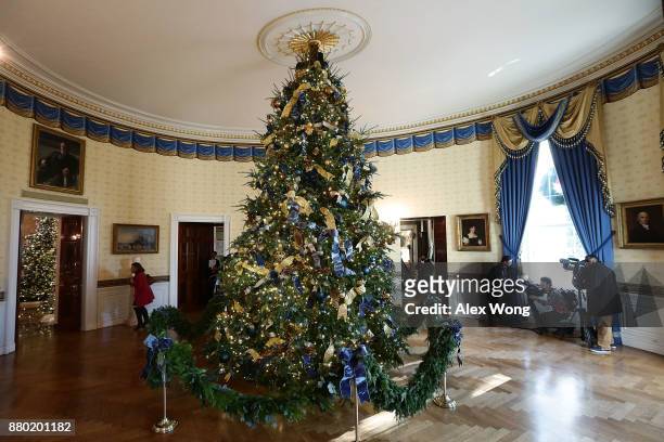 The official White House Christmas tree stands in the Blue Room at the White House during a press preview of the 2017 holiday decorations November...