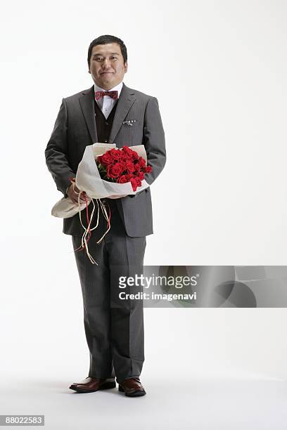 a man in suit holding a bouquet - fat man in suit stock pictures, royalty-free photos & images