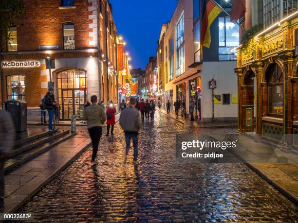 temple bar district of dublin, ireland,  with people passing by during an  autumn evening. this image is gps tagged - temple bar imagens e fotografias de stock