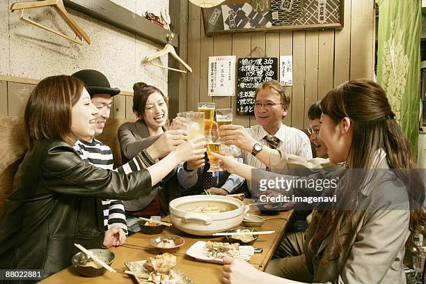 man and woman making a toast in the japanese-style pub - 飲み会　日本 ストックフォトと画像