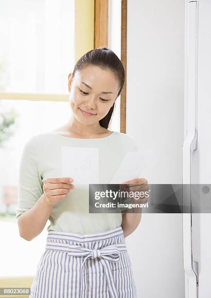 a woman looking at shopping list - woman smiling facing down stock pictures, royalty-free photos & images