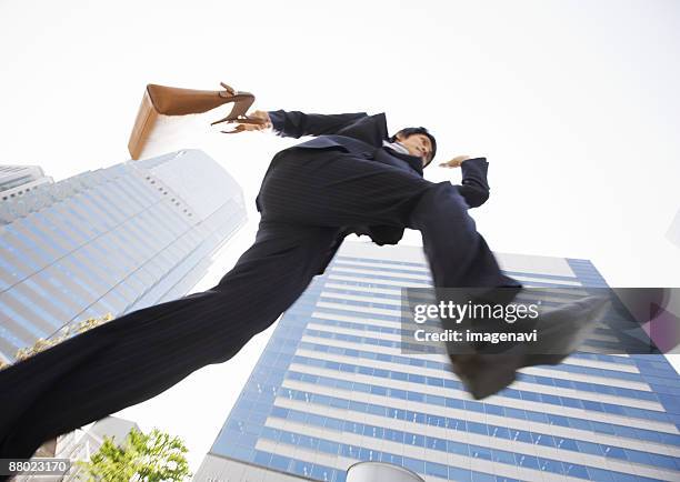 businessman jumping - low angle view ストックフォトと画像