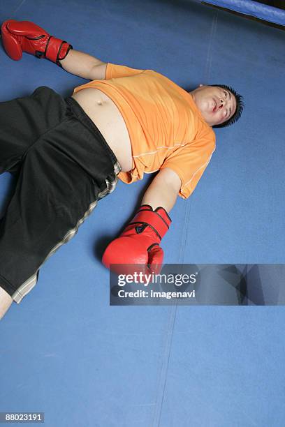 a man knocked down - fat man lying down stock pictures, royalty-free photos & images