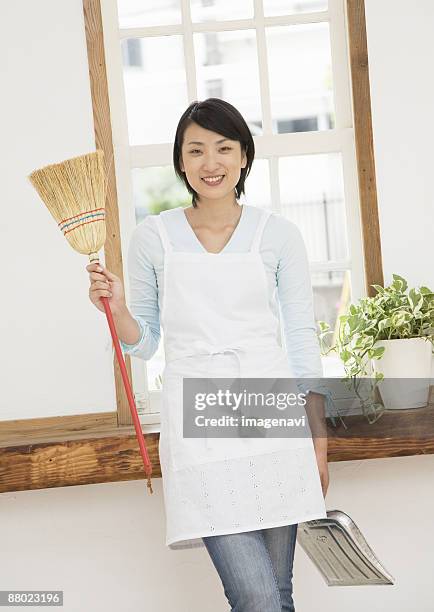 a woman holding broom and dustpan - holding broom stock pictures, royalty-free photos & images