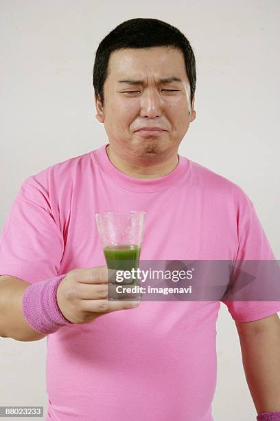 a man drinking green juice - wheatgrass stock pictures, royalty-free photos & images