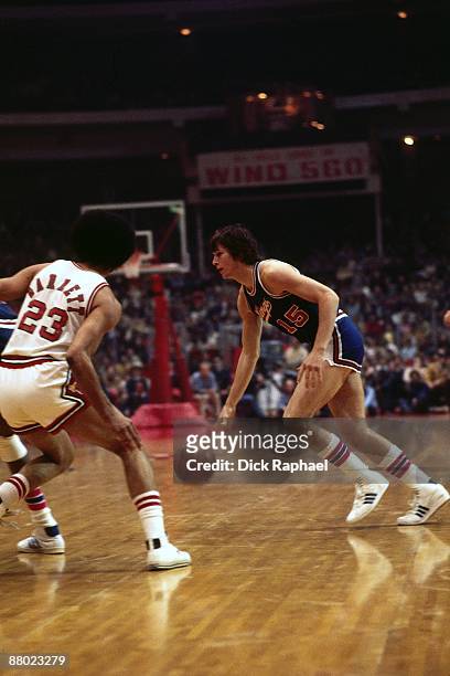 Scott Wedman of the Kansas City Kings moves the ball against Rowland Garrett of the Chicago Bulls during a game played in 1975 at Chicago Stadium in...
