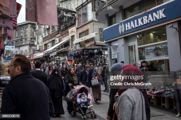 People walk past a branch of the Turkish Halk Bank on November 27, 2017 in Istanbul, Turkey. The trial of Mr. Reza Zarrab an Iranian-Turk who ran a...