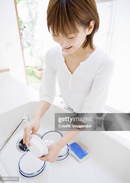 a woman washing dish - woman smiling facing down stock pictures, royalty-free photos & images