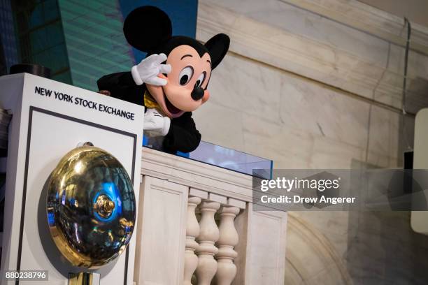 Mickey Mouse, the mascot of The Walt Disney Company, waves before ringing the opening bell at the New York Stock Exchange , November 27, 2017 in New...